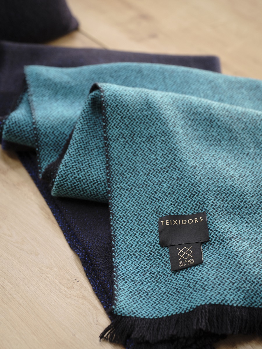 Manta de diseño en lana merina color azul con etiqueta negra de Teixidors